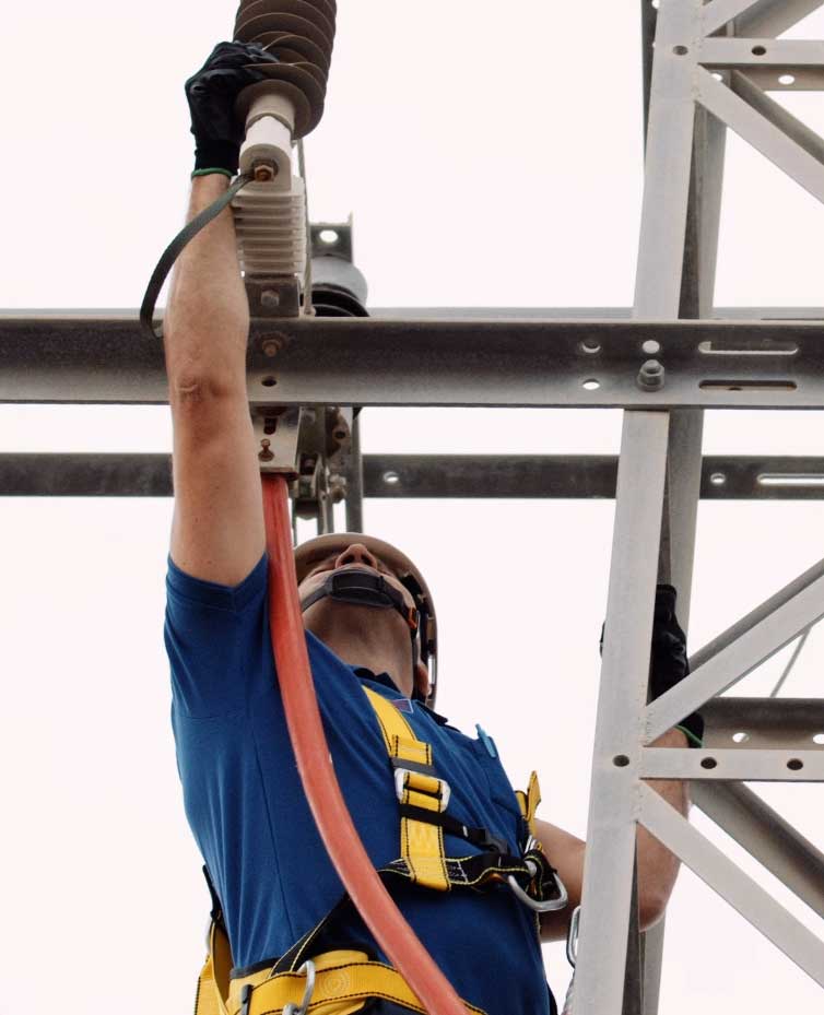 electricista subido a una torre de t4ensión